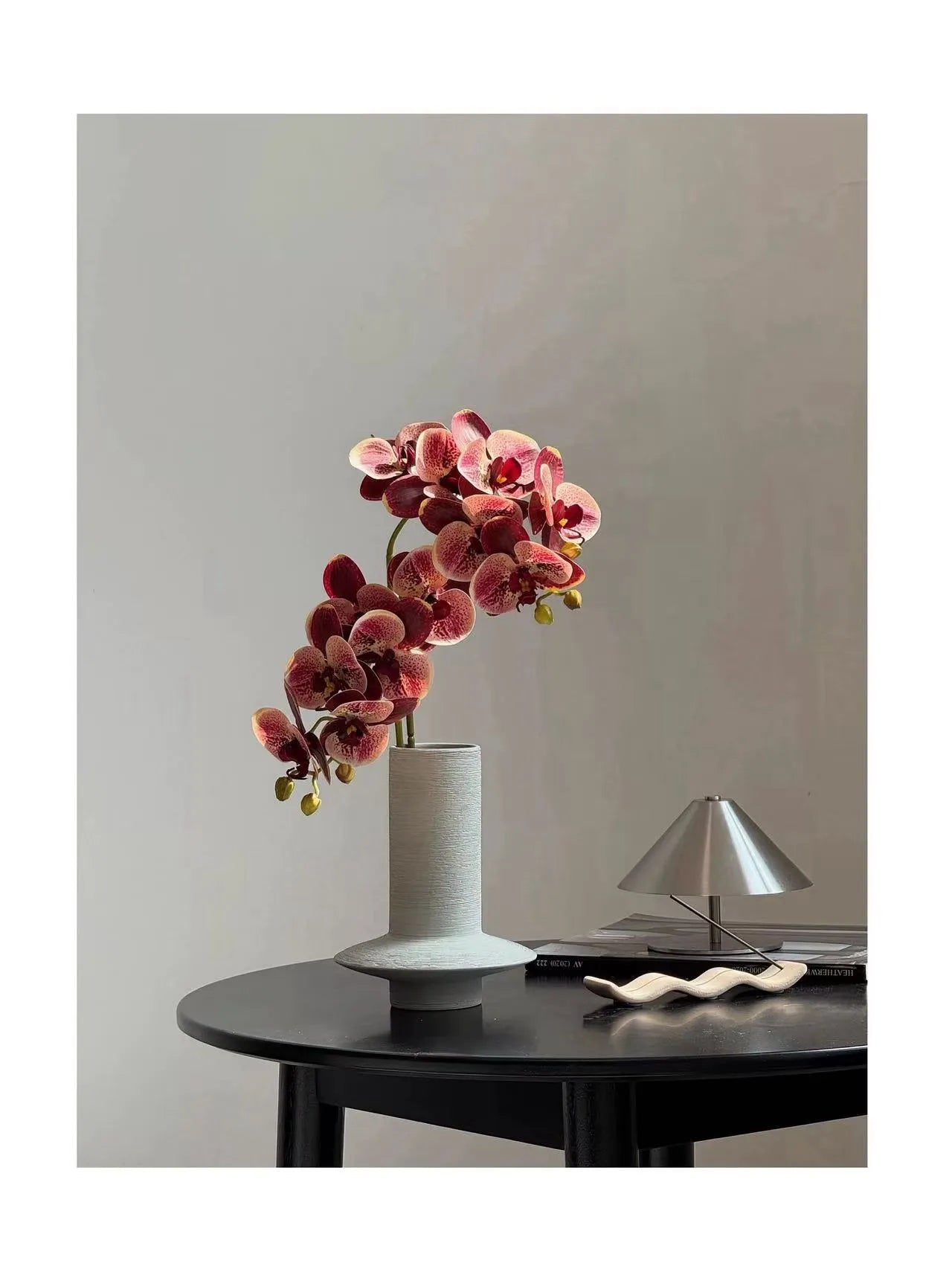 手彫りの花瓶に入ったカラフルなバタフライオーキッド – 花瓶の中の人工的なフラワーアレンジメント