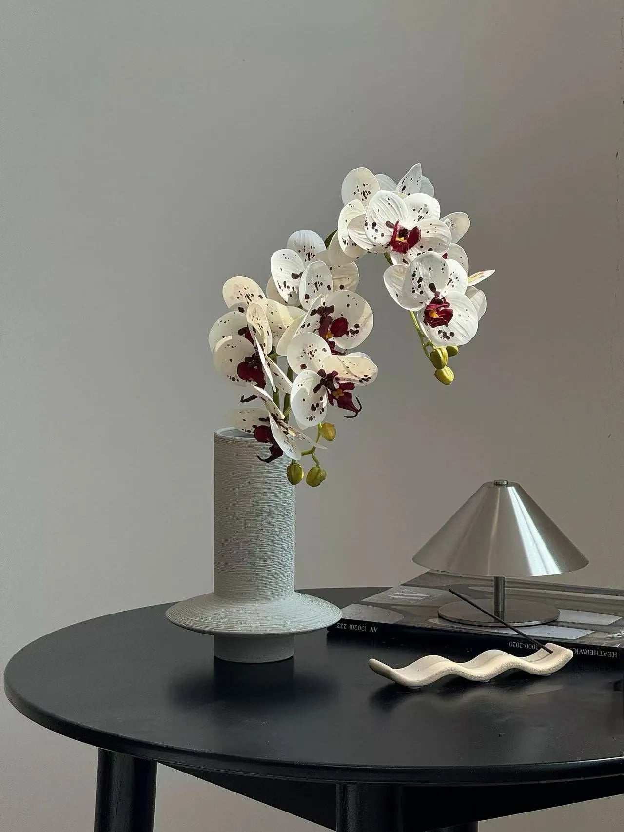 手彫りの花瓶に入ったカラフルなバタフライオーキッド – 花瓶の中の人工的なフラワーアレンジメント