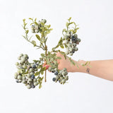Hand-held detail of 38 cm artificial berry spray in grey green
