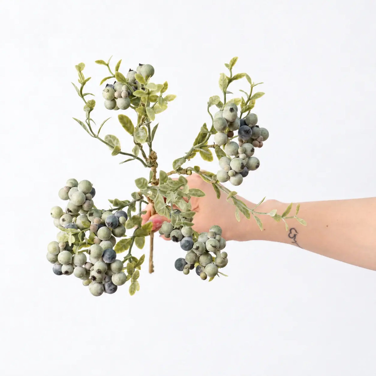 Hand-held detail of 38 cm artificial berry spray in grey green