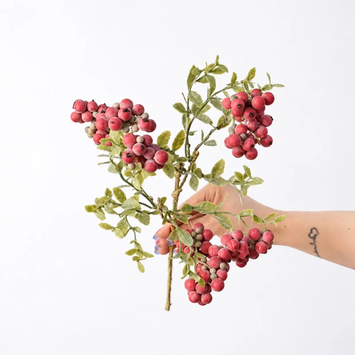 Hand-held detail of 38 cm artificial berry spray in red