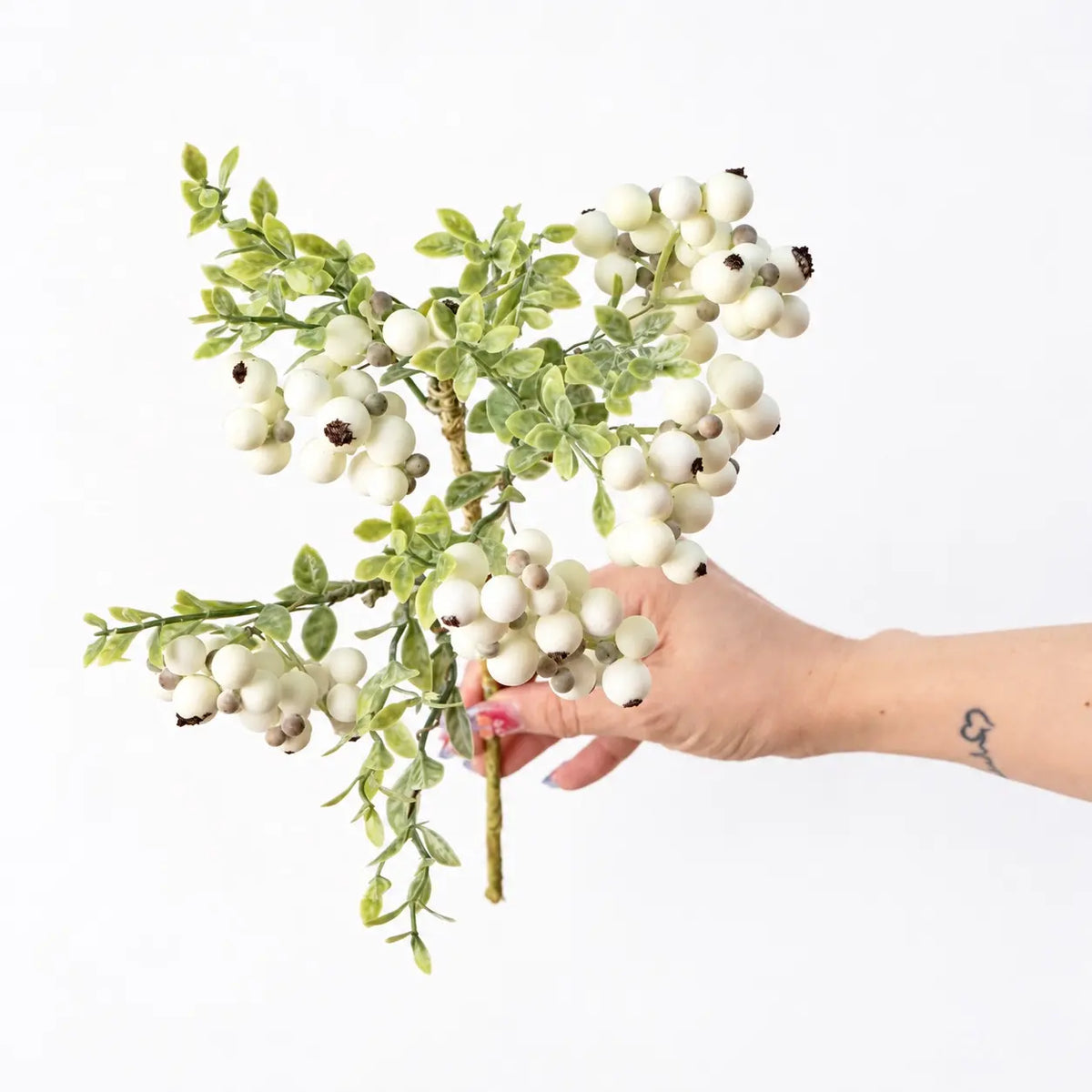 Hand-held detail of 38 cm artificial berry spray in white