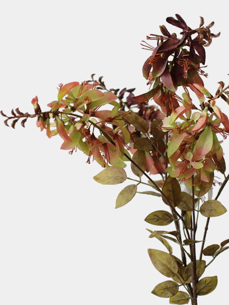 Close-up of green peach-tipped and burgundy artificial erythrina flowers with olive-toned foliage