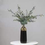 Artificial eucalyptus foliage styled in tall vase