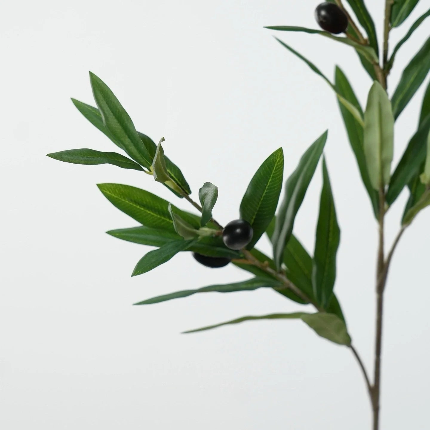 Artificial green olive branch soft touch foliage close up