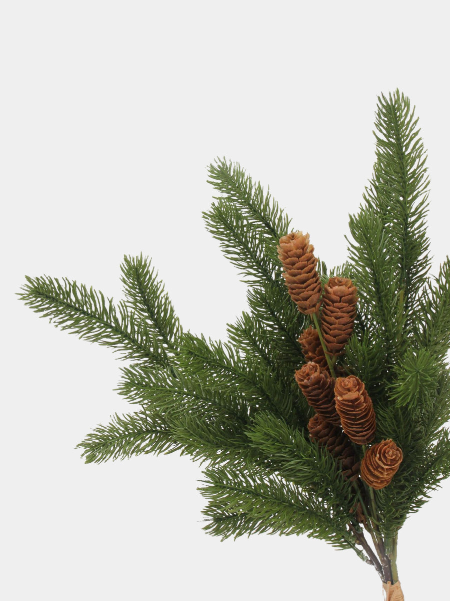 Detailed view of artificial pine foliage, brown cones and raffia-style stem tie