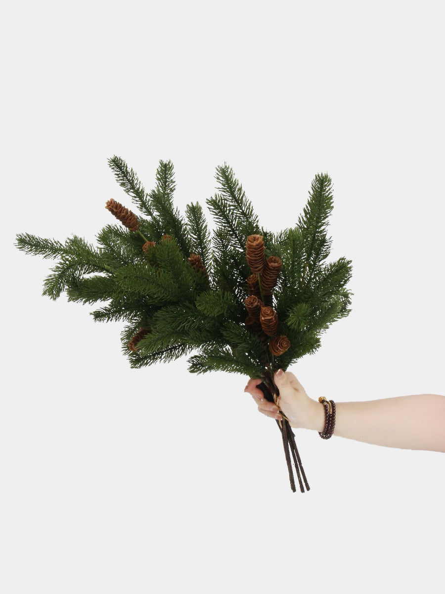 Hand-held artificial pine branches showing the foliage spread and brown stems