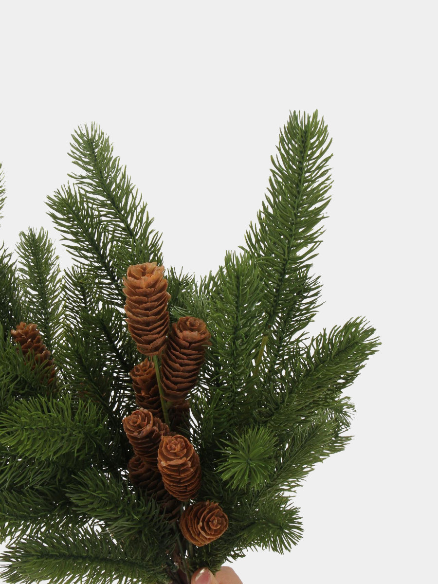 Close-up of green plastic pine needles and elongated brown cones