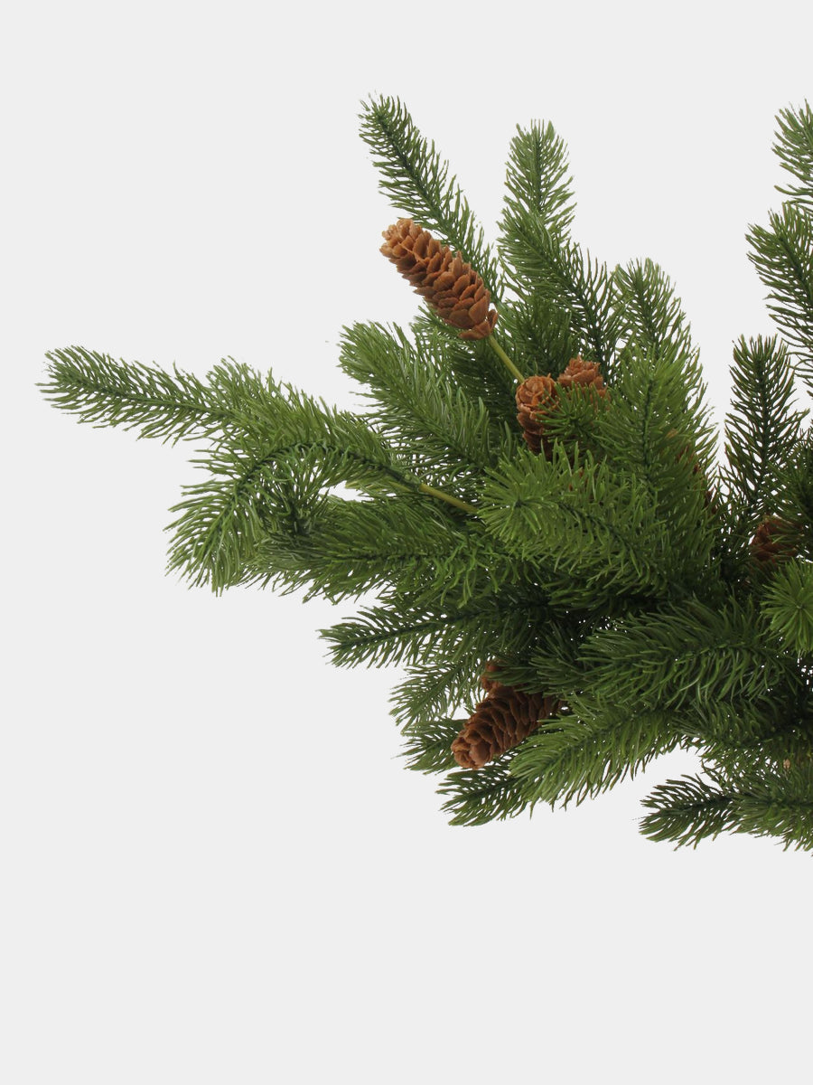 Side view of artificial pine sprays with brown cones among dense green foliage