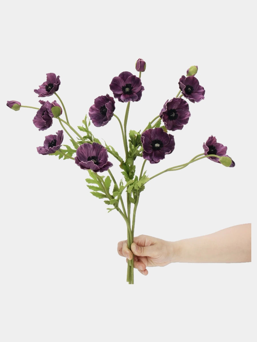 Plum purple artificial poppy stems held in hand to show the flower arrangement
