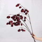 Burgundy faux lantern pod branches shown by hand
