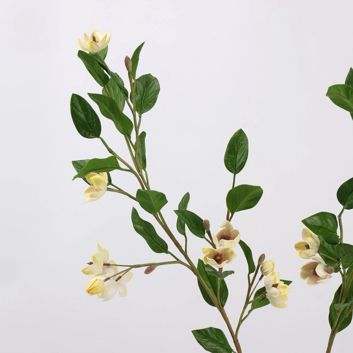 Detail of light yellow faux magnolia flowers and foliage