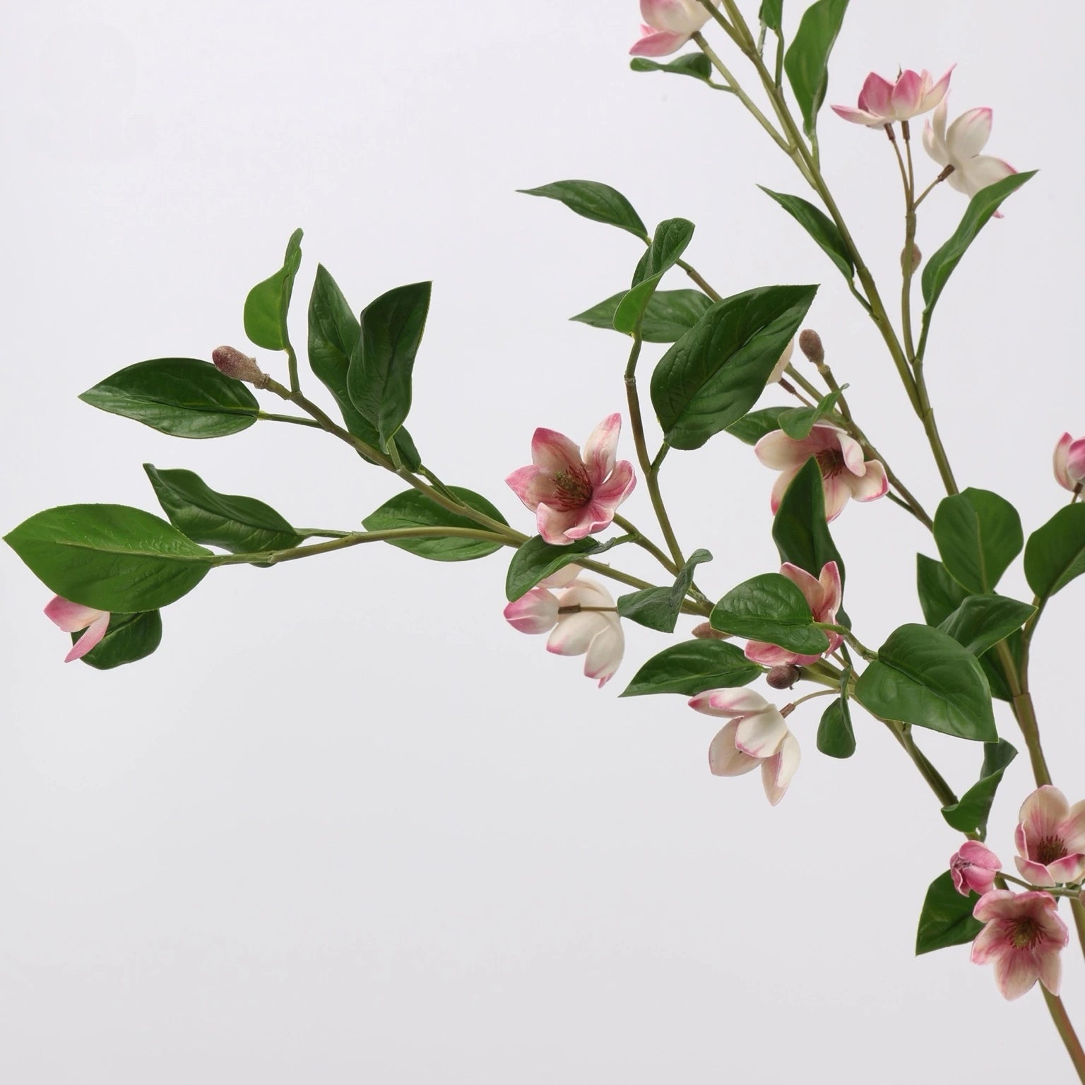 Close-up detail of pink faux magnolia flowers and leaves