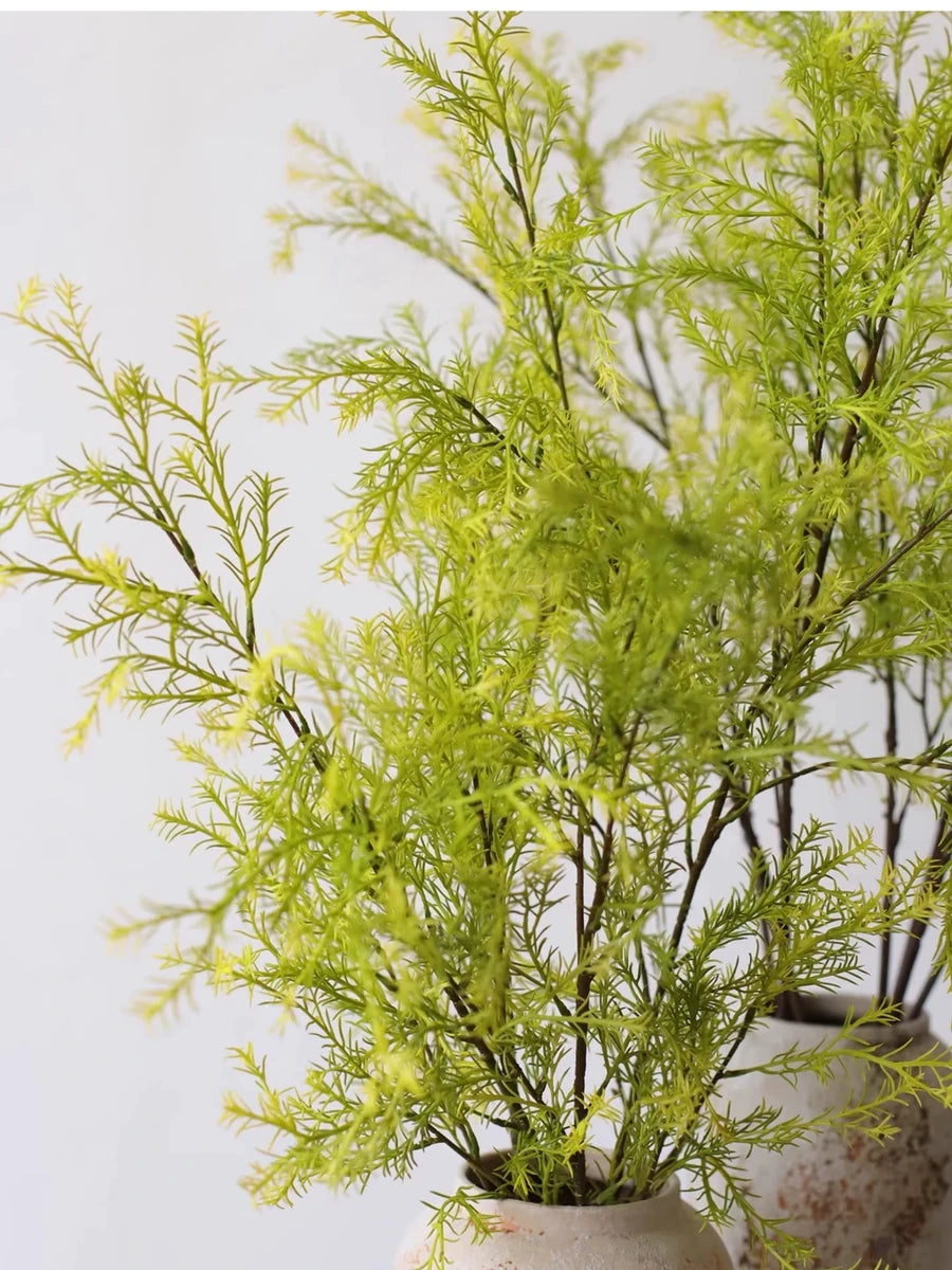 Detail of light green faux melaleuca foliage in a vase