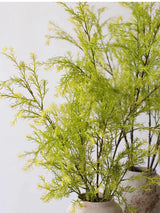 Detail of light green faux melaleuca foliage in a vase
