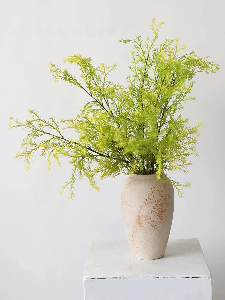 Light green faux melaleuca foliage styled in a vase; vase not included