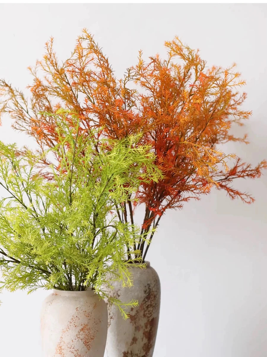 Orange and light green faux melaleuca foliage in styled vases; vases not included