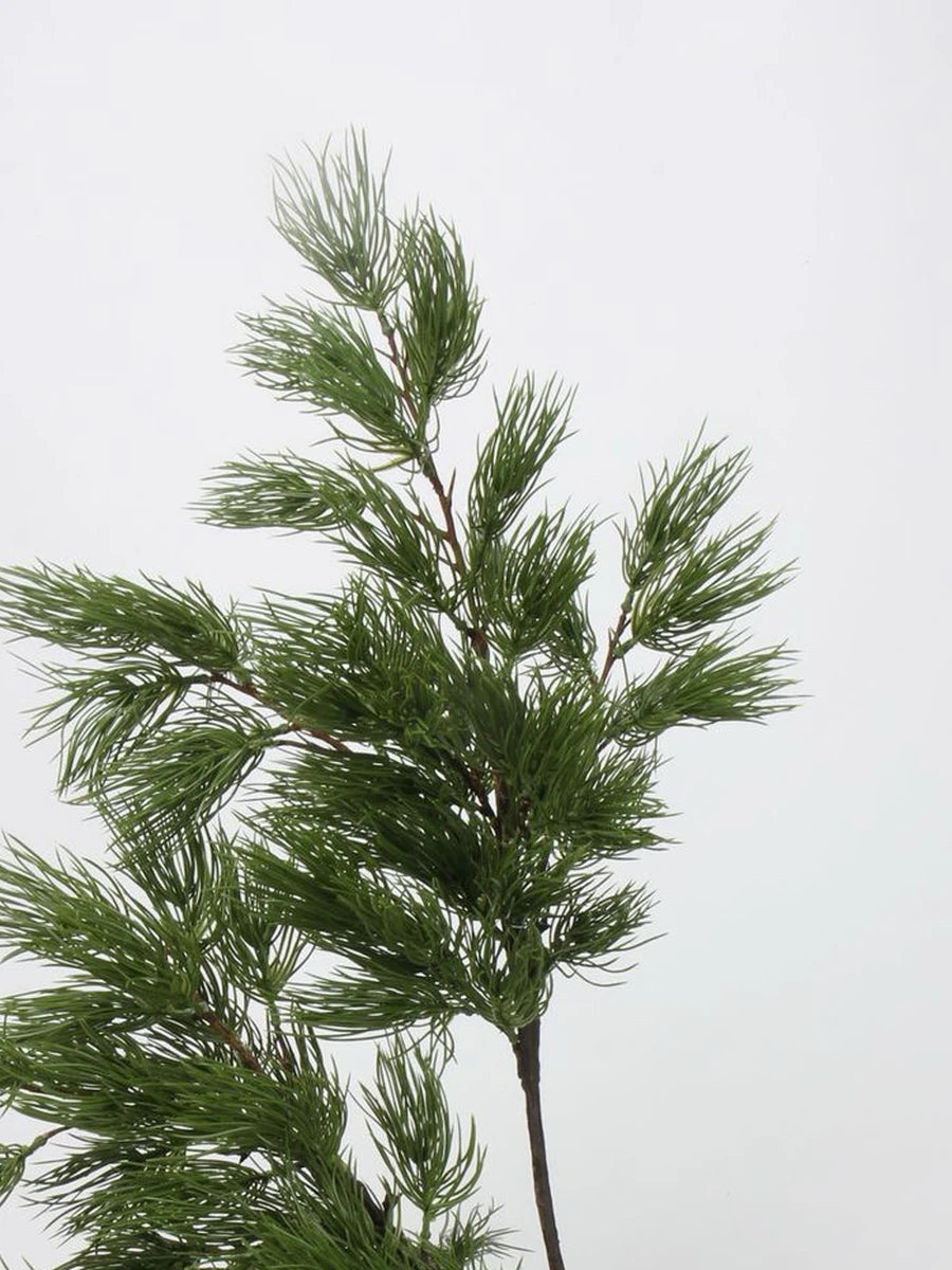 Two green faux pine branches showing foliage shape