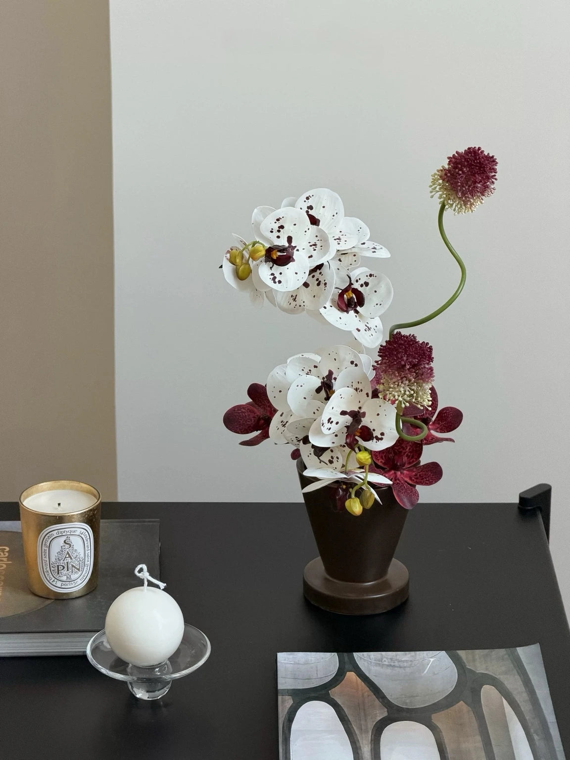 Artificial orchid arrangement styled on a dark console