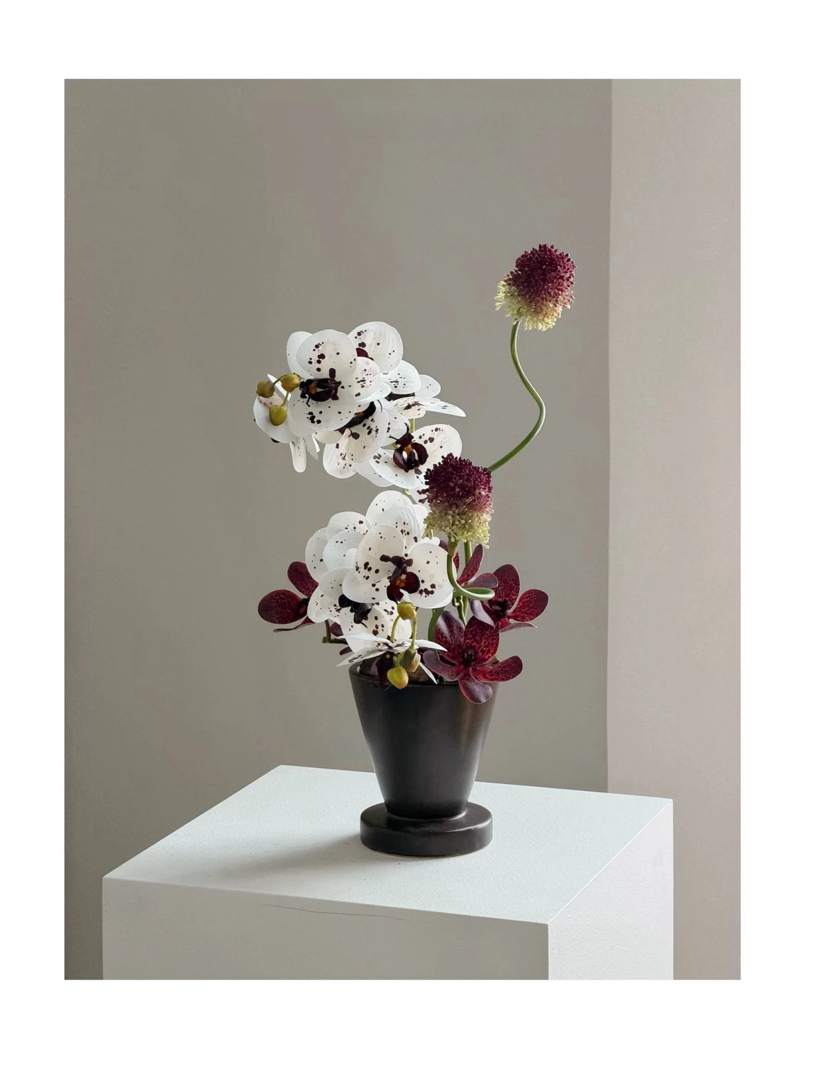 Monroe faux orchid arrangement on white plinth