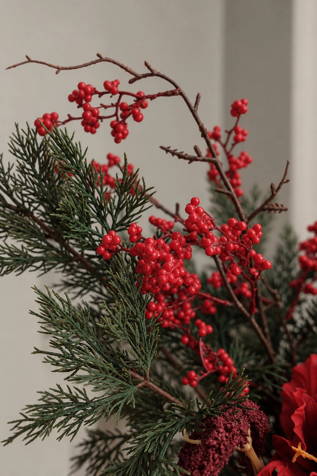 Red berry clusters and evergreen foliage in the Noël Christmas bouquet