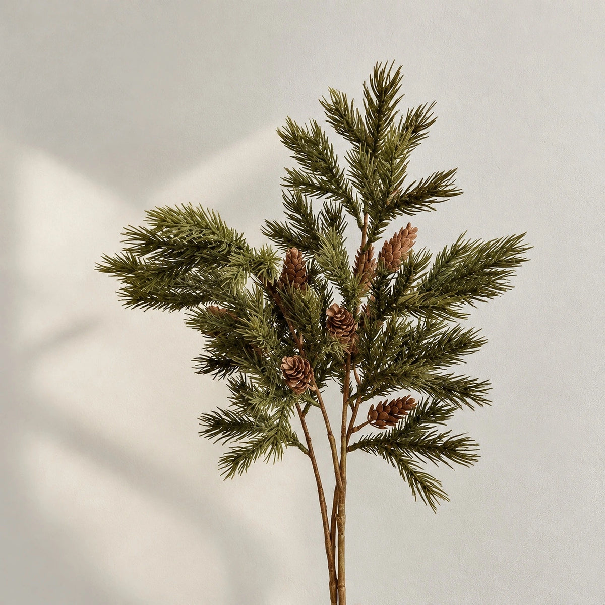 Faux Norfolk pine branches with green needles and brown pine cones
