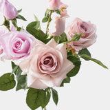 Mixed pink and lilac Real Touch artificial rose stems showing petal texture and green leaves