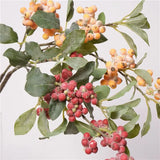 Orange and red faux berry clusters and leaves, close-up